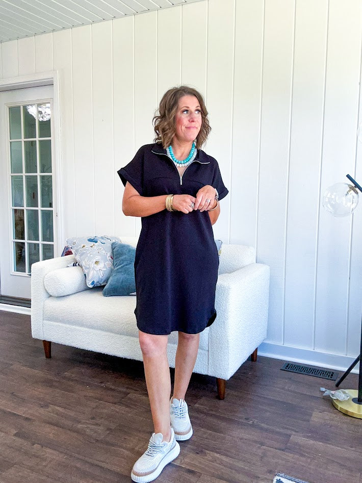 The scoop hem is a flattering fit that is sure to be the star of the show. This black 1/4 zip dress combines comfort with contemporary style, featuring a distinctive scoop hem that creates an elegant silhouette.
