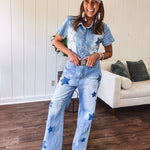 Light wash denim jumpsuit with button front, collar and star patches throughout with front and back pockets. Wide leg design.