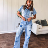 Light wash denim jumpsuit with button front, collar and star patches throughout with front and back pockets. Wide leg design.