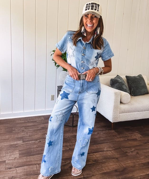 Light wash denim jumpsuit with button front, collar and star patches throughout with front and back pockets. Wide leg design.