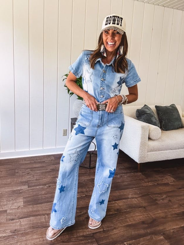 Light wash denim jumpsuit with button front, collar and star patches throughout with front and back pockets. Wide leg design.