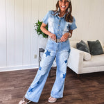 Light wash denim jumpsuit with button front, collar and star patches throughout with front and back pockets. Wide leg design.