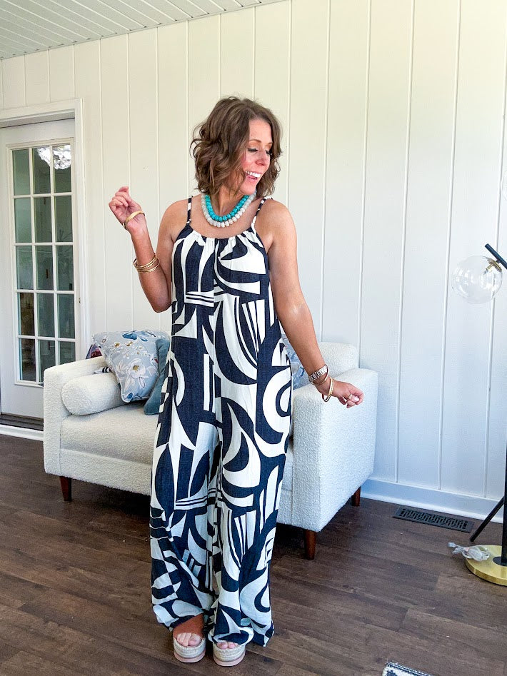 Turn heads this season in our Black + Cream Abstract Trellis Jumpsuit—the effortless piece that does all the work for you. Crafted from lightweight, breathable polyester, this playful abstract print jumpsuit features adjustable straps with a drawstring at the back, elastic neckline details, and a flattering wide-leg silhouette that moves with you. 