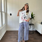 White oversized tee featuring a mixed print of black, red and cream in western, leo and playing card theme.