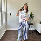 White oversized tee featuring a mixed print of black, red and cream in western, leo and playing card theme.