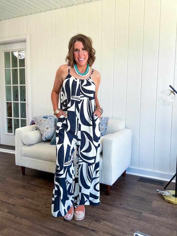 Turn heads this season in our Black + Cream Abstract Trellis Jumpsuit—the effortless piece that does all the work for you. Crafted from lightweight, breathable polyester, this playful abstract print jumpsuit features adjustable straps with a drawstring at the back, elastic neckline details, and a flattering wide-leg silhouette that moves with you. 