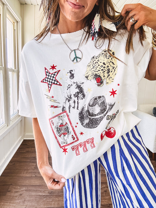 White oversized tee featuring a mixed print of black, red and cream in western, leo and playing card theme.