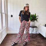 Thin, silky classic leopard design wide leg pants with red number 7 billiard balls throughout with red, white and black stripe down the sides and elastic drawstring waist and pockets.