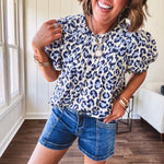 Thin, lightweight flowy puff sleeve blouse with pintuck detail at the yoke and shades of blue leopard print throughout.
