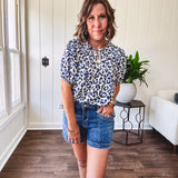 Thin, lightweight flowy puff sleeve blouse with pintuck detail at the yoke and shades of blue leopard print throughout.