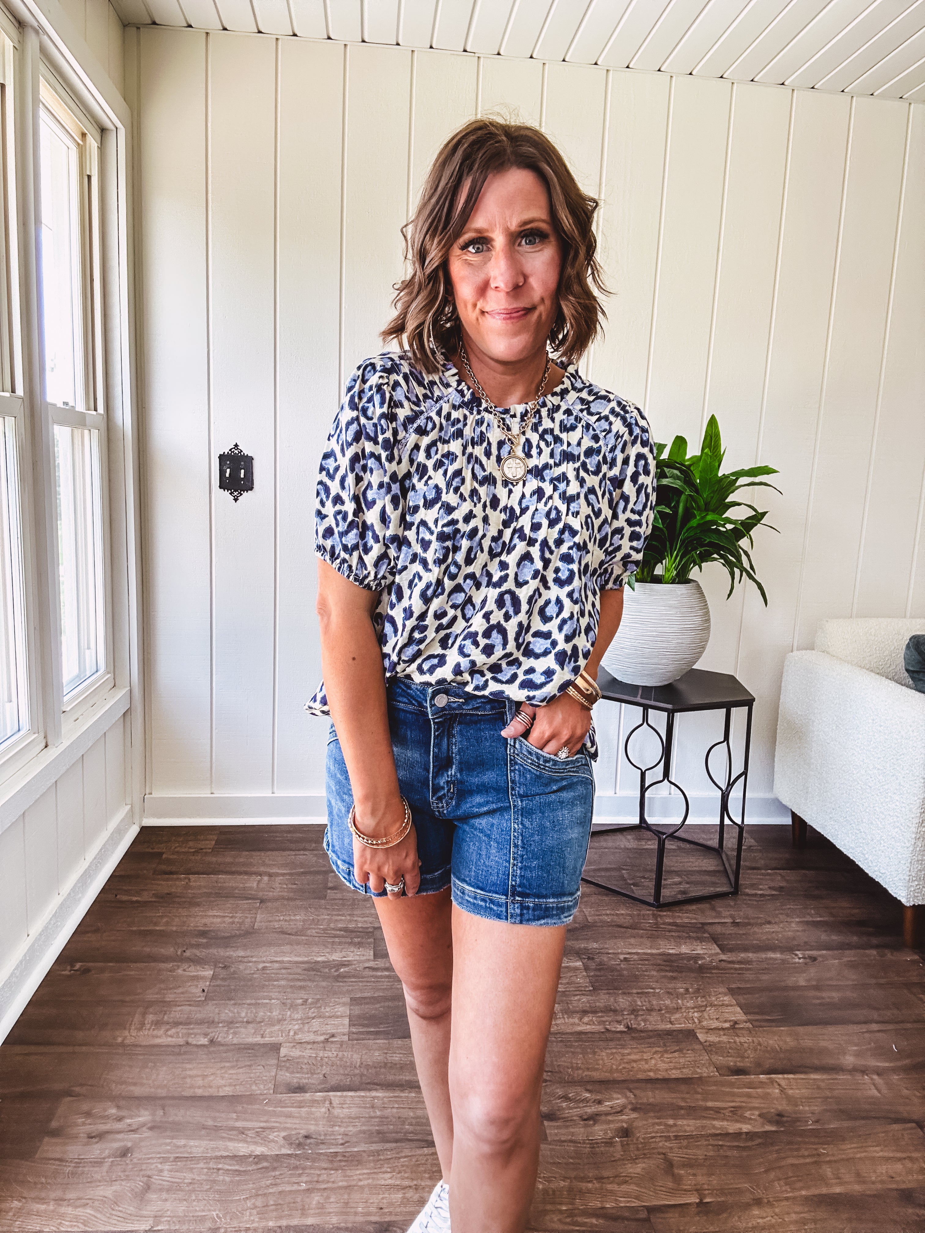 Thin, lightweight flowy puff sleeve blouse with pintuck detail at the yoke and shades of blue leopard print throughout.