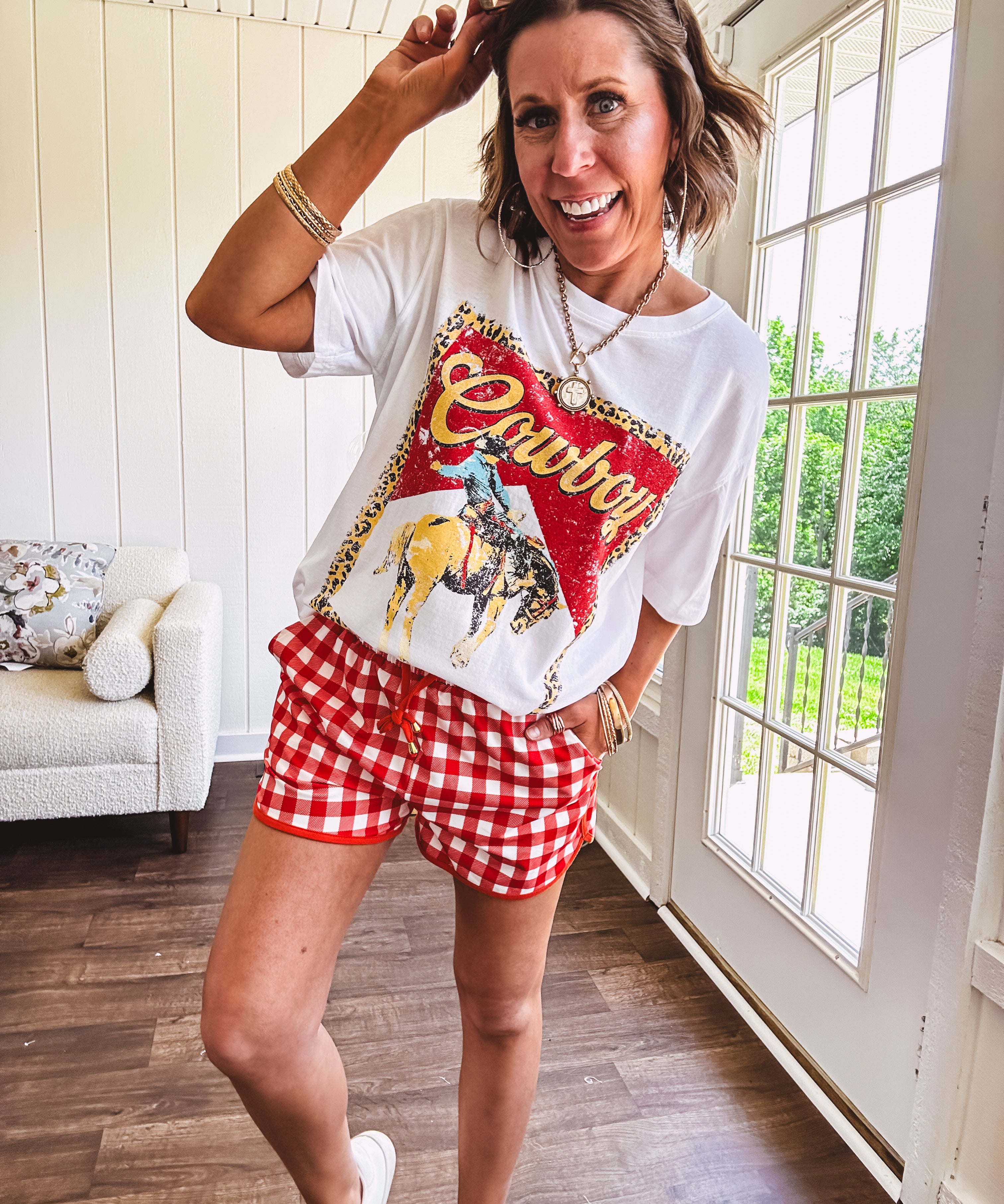 Thin, lightweight orange/red gingham athleisure shorts with elastic drawstring waist, pockets and matching trim.