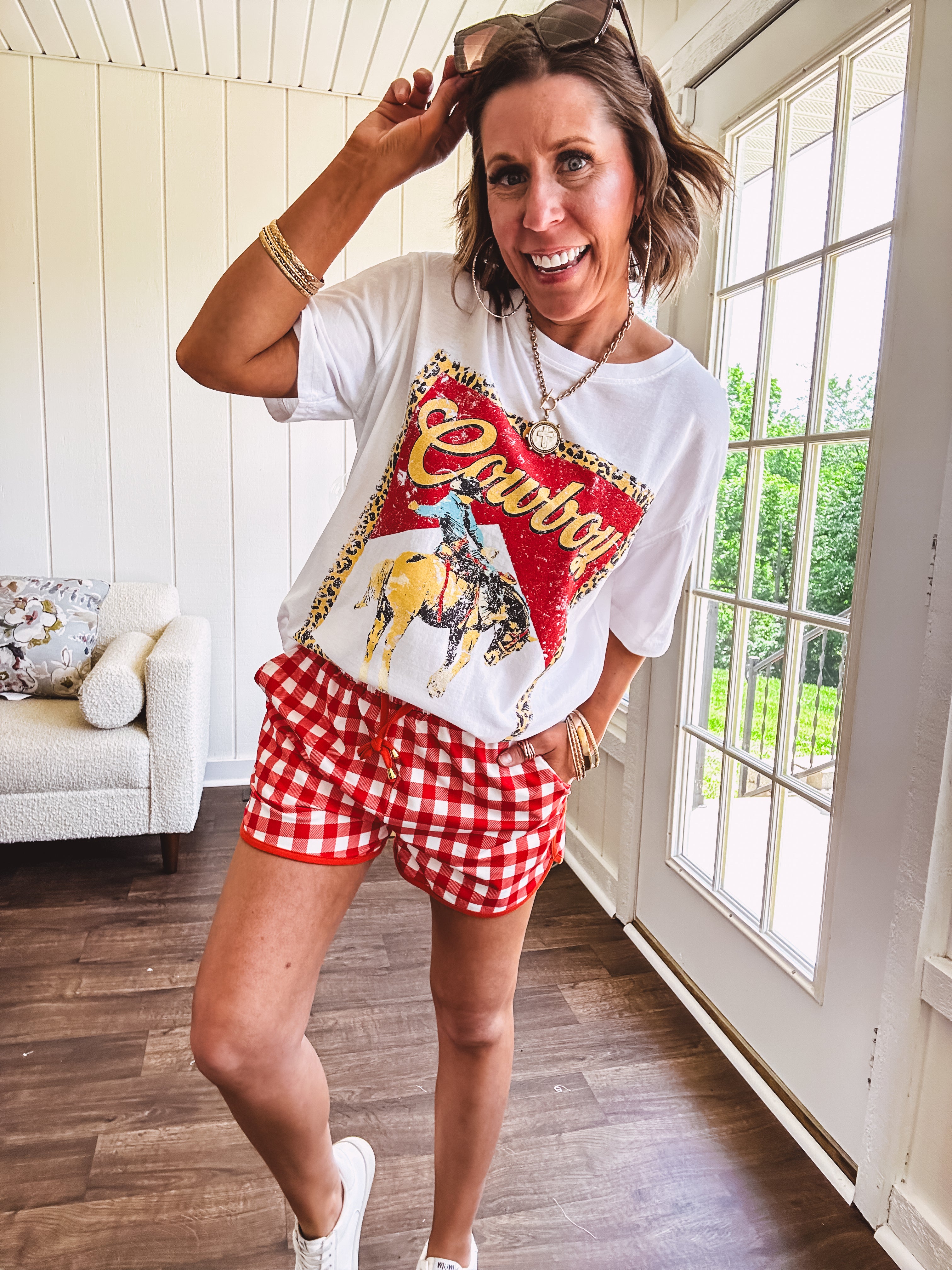 Thin, lightweight orange/red gingham athleisure shorts with elastic drawstring waist, pockets and matching trim.