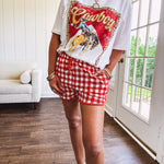 Thin, lightweight orange/red gingham athleisure shorts with elastic drawstring waist, pockets and matching trim.