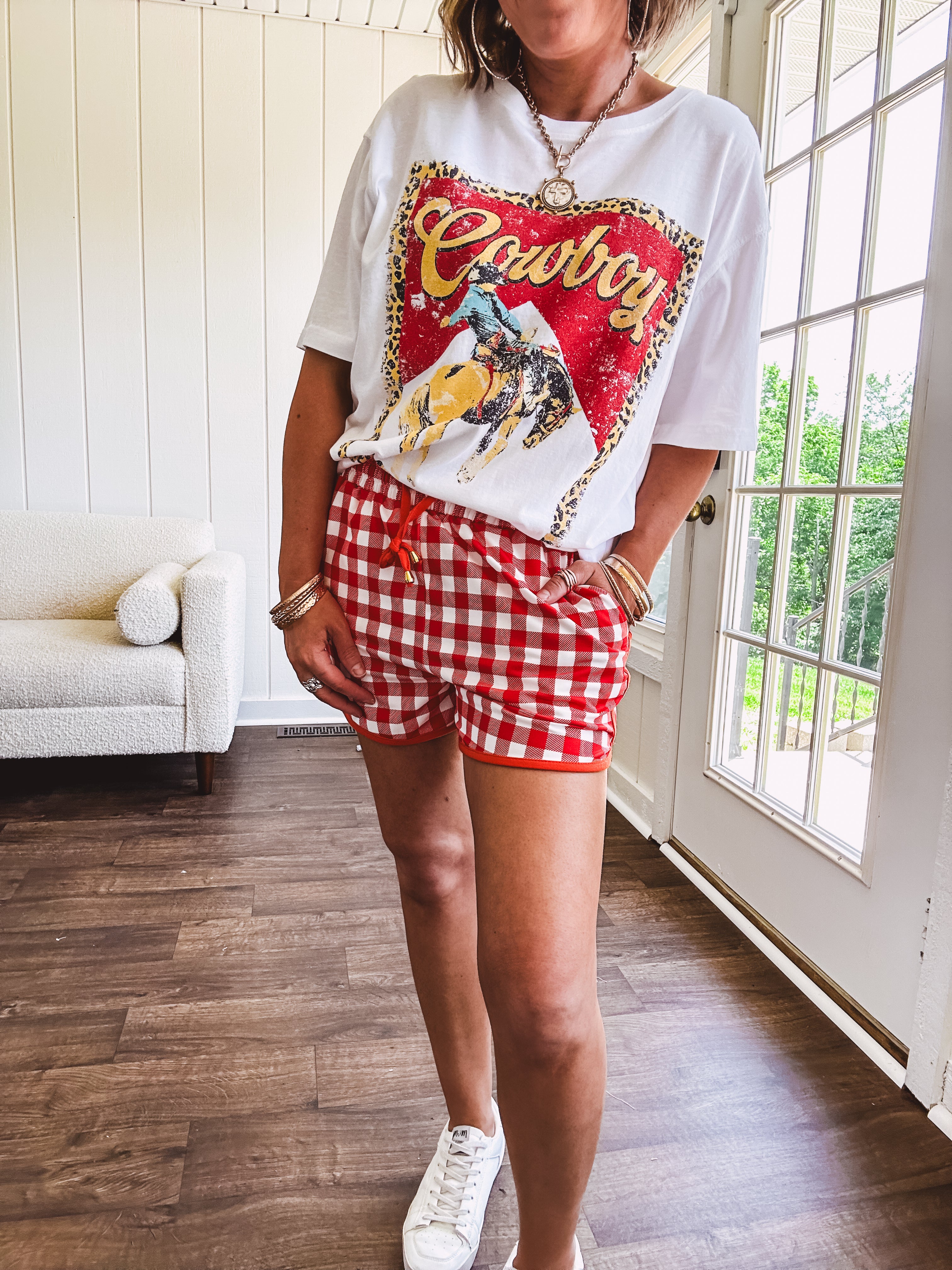 Thin, lightweight orange/red gingham athleisure shorts with elastic drawstring waist, pockets and matching trim.