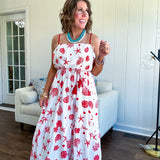 This fully lined white midi features an eye-catching red shell print that demands attention, paired with adjustable red spaghetti straps and a show-stopping red and white striped rope belt complete with charming tassels.