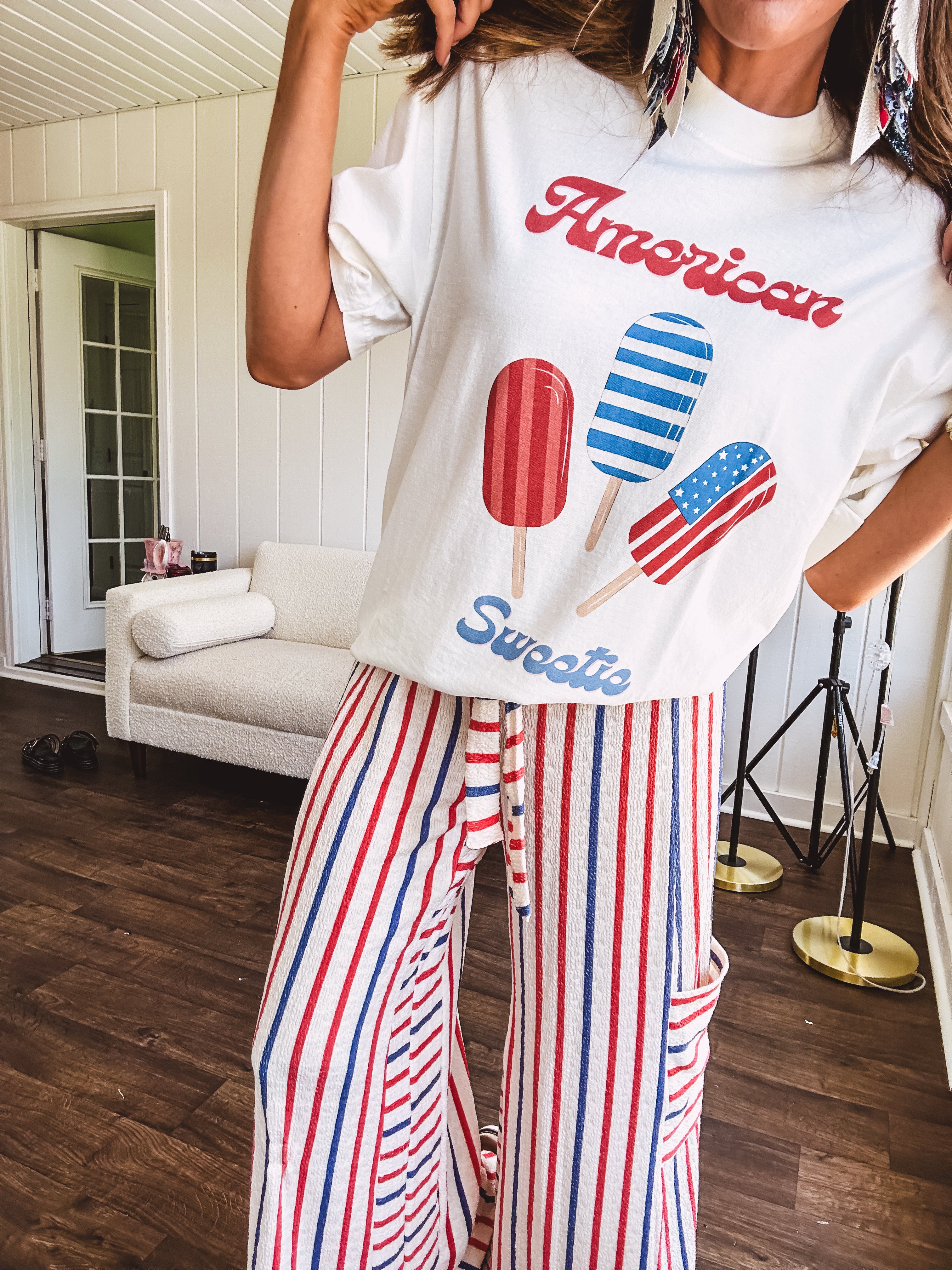 White cotton tee with blue and red "American Sweet" and popsicle graphics on front.
