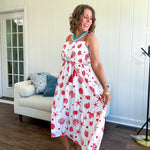 This fully lined white midi features an eye-catching red shell print that demands attention, paired with adjustable red spaghetti straps and a show-stopping red and white striped rope belt complete with charming tassels.
