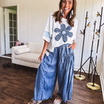 Soft, thin, lightweight 3/4 sleeve heather grey top with denim blue floral patchwork on the front and light blue patchwork on the sleeves and trim.