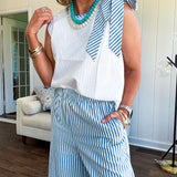 The lightweight cream tank features a playful blue and white striped bow at the shoulder and matching trim around the round neckline, finished with a hook and eye closure. Pair it with the coordinating wide-leg pants, complete with pockets and that same breezy stripe detail at the waist.