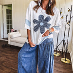 Soft, thin, lightweight 3/4 sleeve heather grey top with denim blue floral patchwork on the front and light blue patchwork on the sleeves and trim.