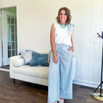 The lightweight cream tank features a playful blue and white striped bow at the shoulder and matching trim around the round neckline, finished with a hook and eye closure. Pair it with the coordinating wide-leg pants, complete with pockets and that same breezy stripe detail at the waist.