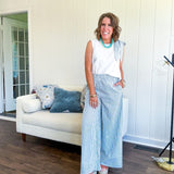 The lightweight cream tank features a playful blue and white striped bow at the shoulder and matching trim around the round neckline, finished with a hook and eye closure. Pair it with the coordinating wide-leg pants, complete with pockets and that same breezy stripe detail at the waist.