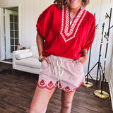 Cotton blend red and white striped shorts with elastic drawstring waist and embroidered red scalloped hem and pockets.