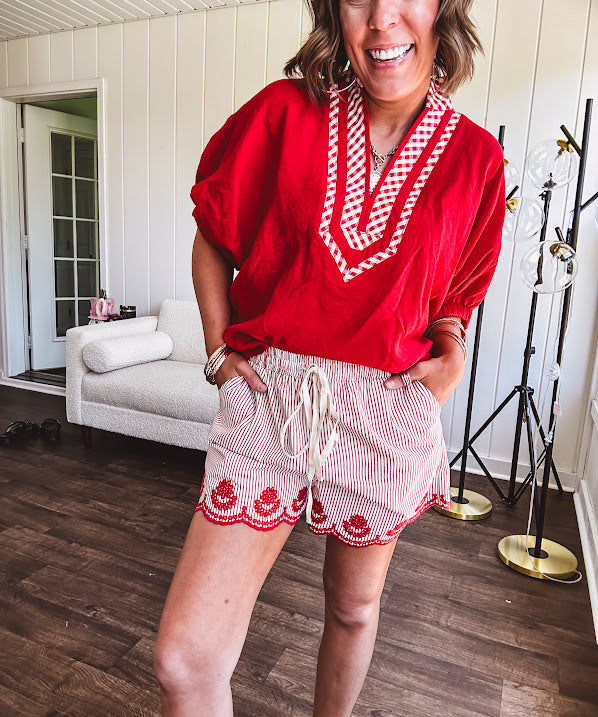 Cotton blend red and white striped shorts with elastic drawstring waist and embroidered red scalloped hem and pockets.