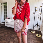 Cotton blend red and white striped shorts with elastic drawstring waist and embroidered red scalloped hem and pockets.