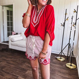 Cotton blend red and white striped shorts with elastic drawstring waist and embroidered red scalloped hem and pockets.