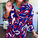 Soft, lightweight set featuring a 3/4 tab sleeve top with button down front and collar with matching elastic waist shorts with front pleats and pockets as well as lining in a bold navy, orange and white modern print.
