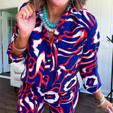 Soft, lightweight set featuring a 3/4 tab sleeve top with button down front and collar with matching elastic waist shorts with front pleats and pockets as well as lining in a bold navy, orange and white modern print.