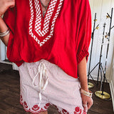 Cotton blend red and white striped shorts with elastic drawstring waist and embroidered red scalloped hem and pockets.