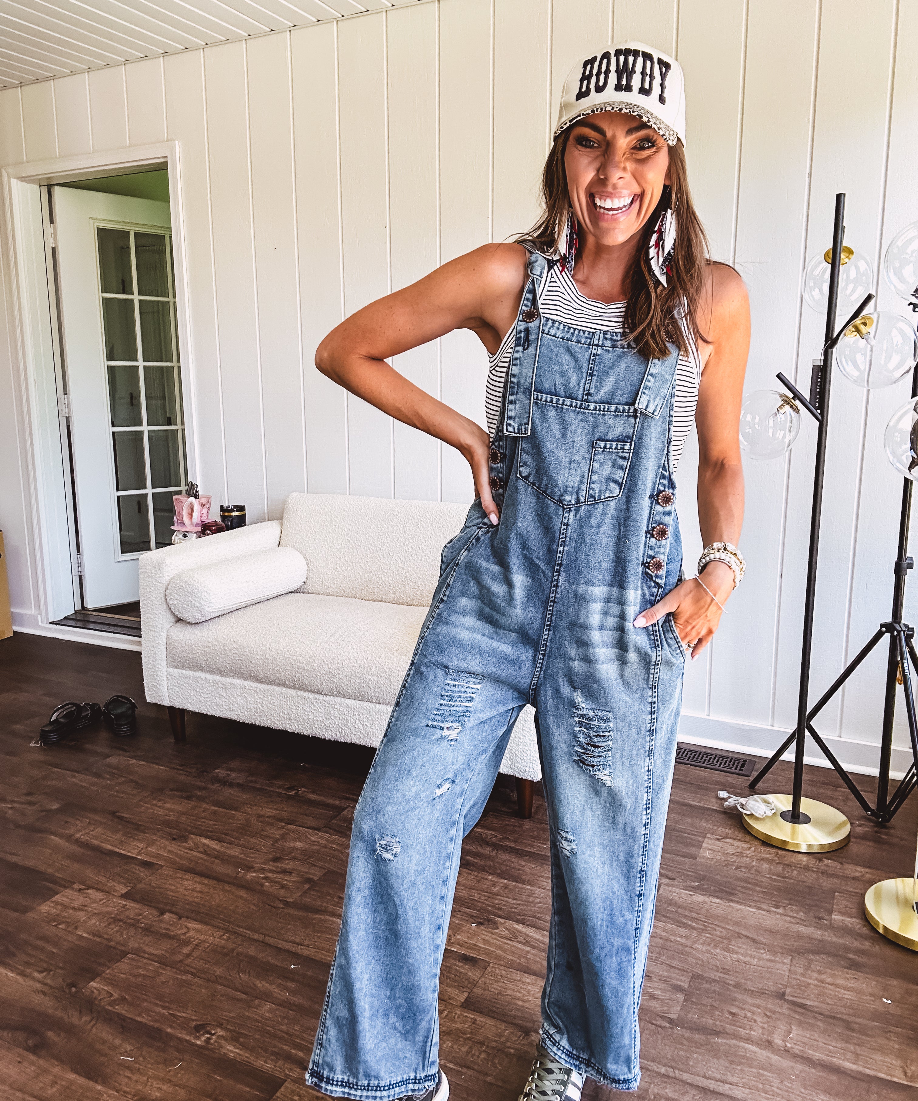 Loose fit medium wash denim overalls with adjustable button straps and sides and distressing throughout.