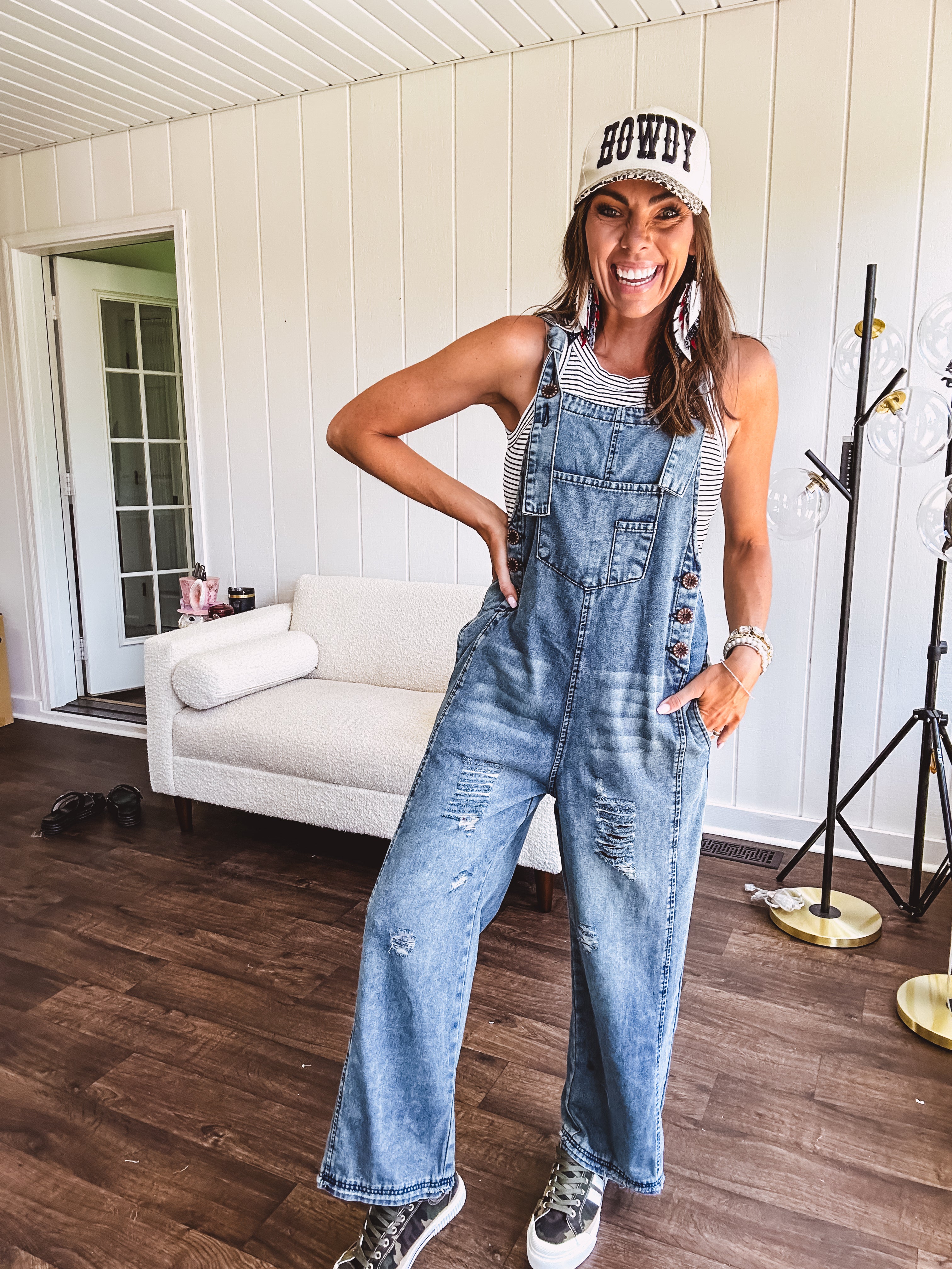 Loose fit medium wash denim overalls with adjustable button straps and sides and distressing throughout.