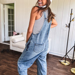 Loose fit medium wash denim overalls with adjustable button straps and sides and distressing throughout.