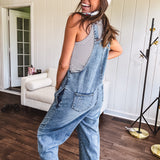 Loose fit medium wash denim overalls with adjustable button straps and sides and distressing throughout.