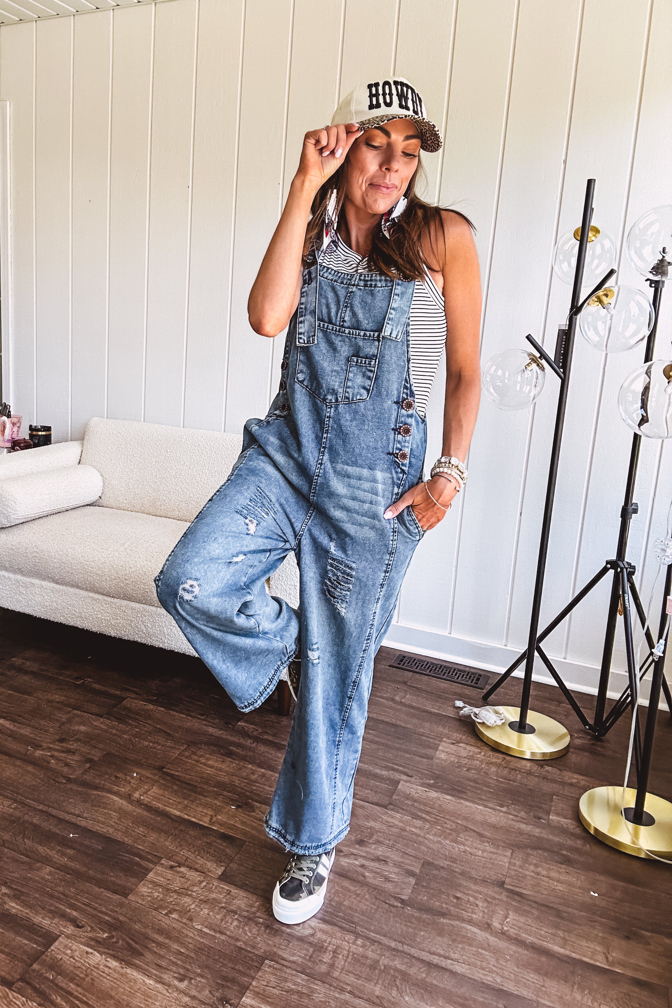 Loose fit medium wash denim overalls with adjustable button straps and sides and distressing throughout.