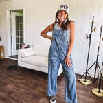 Loose fit medium wash denim overalls with adjustable button straps and sides and distressing throughout.