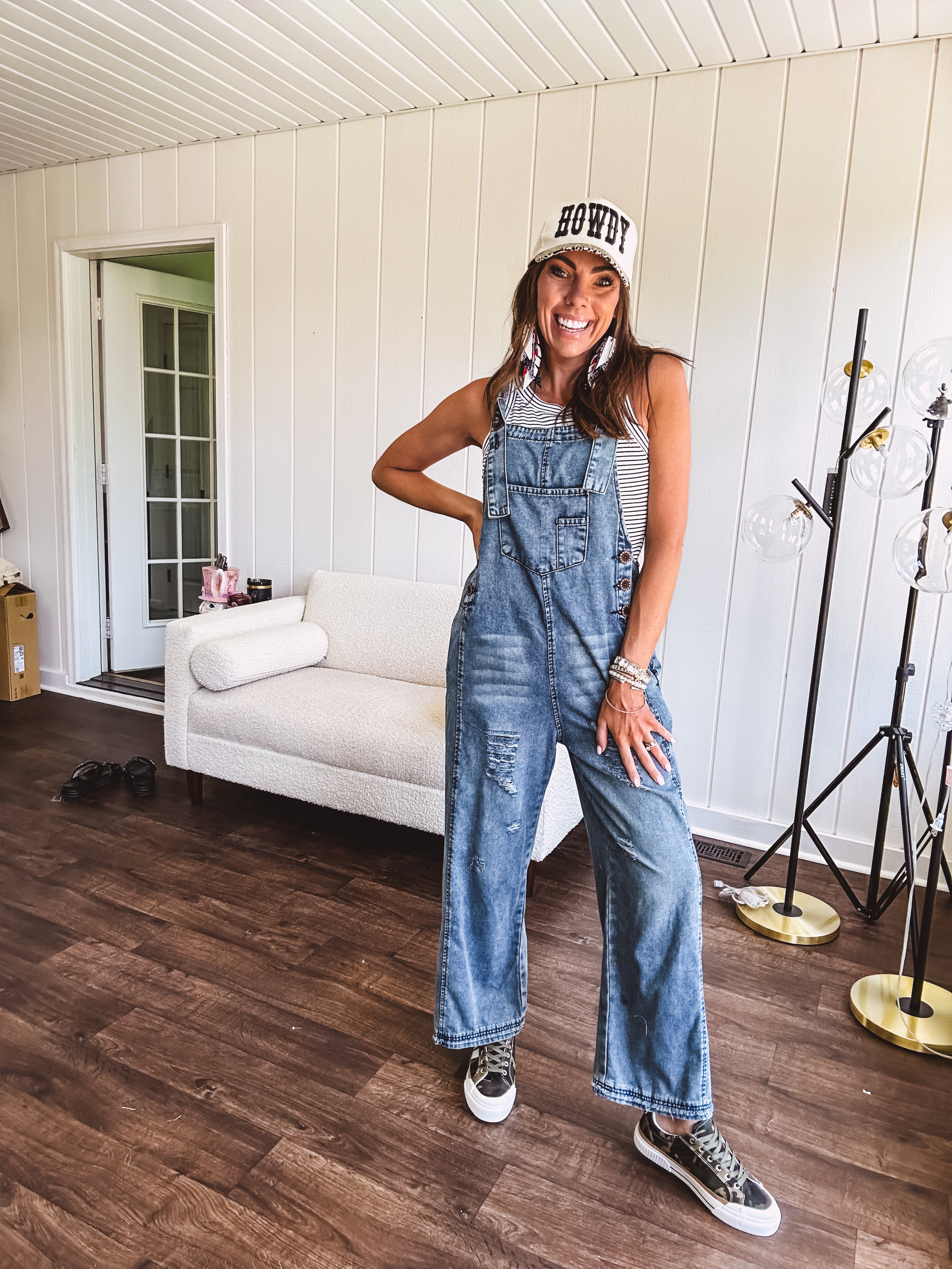 Loose fit medium wash denim overalls with adjustable button straps and sides and distressing throughout.