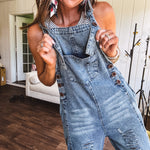Loose fit medium wash denim overalls with adjustable button straps and sides and distressing throughout.