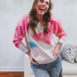Crew style sweater featuring pastel swirl patterns in pink, blue and yellow accentuated by rhinestones.