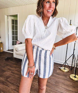Cotton blend cream and navy striped shorts with full lining, hook and zipper closure, elastic back at the waist and side pockets with faux back pockets.