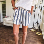 Cotton blend cream and navy striped shorts with full lining, hook and zipper closure, elastic back at the waist and side pockets with faux back pockets.