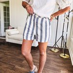 Cotton blend cream and navy striped shorts with full lining, hook and zipper closure, elastic back at the waist and side pockets with faux back pockets.