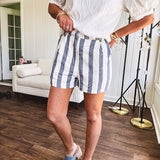 Cotton blend cream and navy striped shorts with full lining, hook and zipper closure, elastic back at the waist and side pockets with faux back pockets.