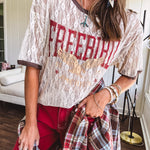 Floral lace sheer tee with brown trim throughout and red "FREEBIRD" and cream eagle graphic.
