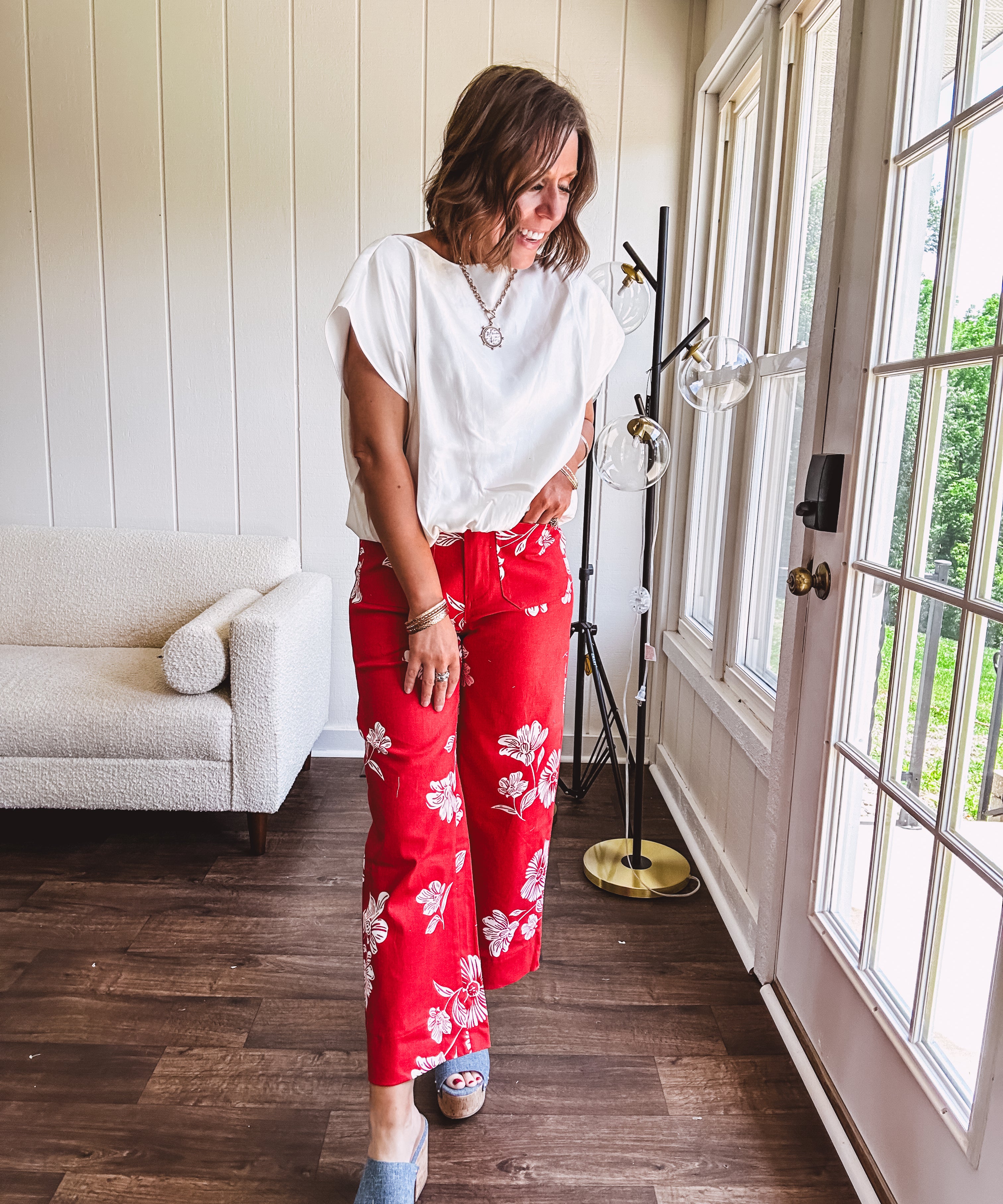 Wide leg cropped red pants with white florals throughout, button and zipper closure, wide cuffs and square front pockets. Minimal stretch