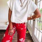 Shimmery white short sleeved top with elastic bubble hem and boat neck design.